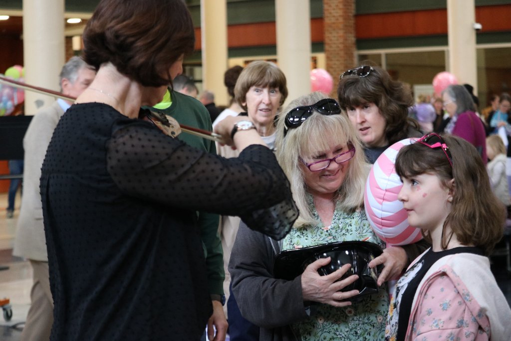 FSO musician introducing a young audience member to a violin at a Lollipops community concert